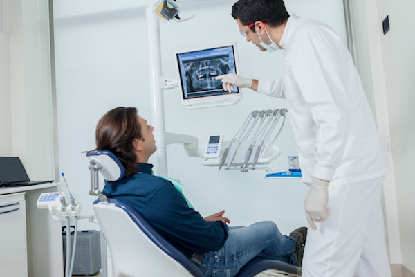 Dentist is showing his patient on the monitor what he is going to do