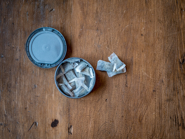 Swedish Nicotine. Portion Snus in container on wood background.