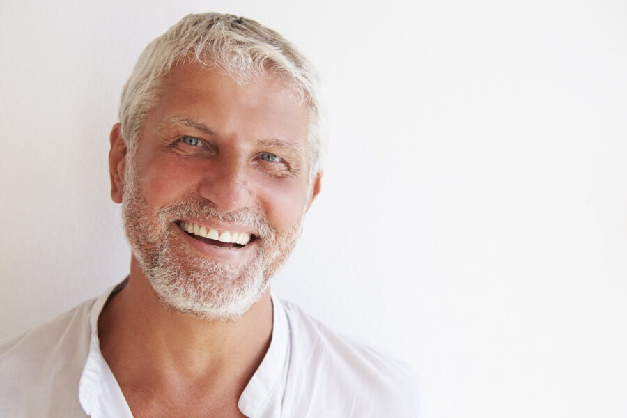 Portrait Of Mature Man Standing Against Wall