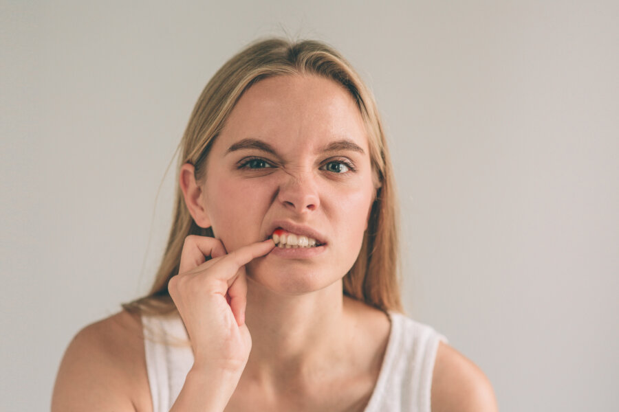 A woman checking her gums and jaw alignment. 