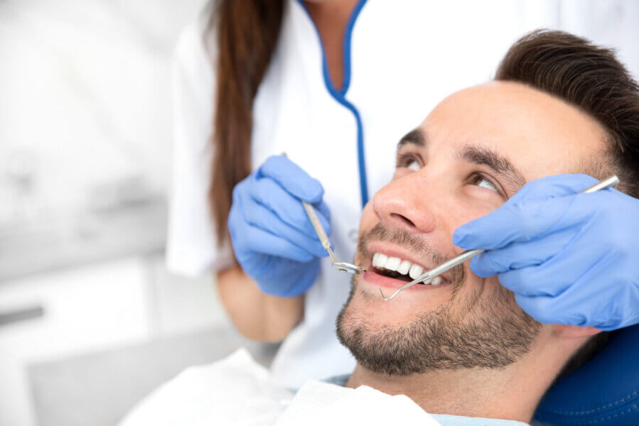 periodontist Man having teeth examined at dentists. Overview of dental caries prevention